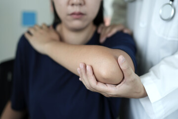 Physiotherapist doing physiotherapy for patient in a hospital room, helps to recover from shoulder pain by moving the arm, body and muscles. The concept of treating illnesses with physical therapy.