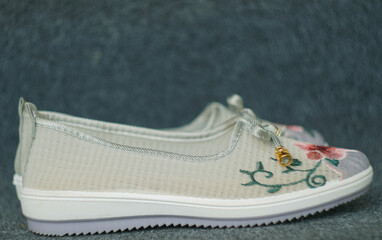 Girls' shoes in floral fabric on the carpet