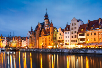 Obraz premium Gdansk riverside glows with architectural elegance as twilight deepens. Historic facades and calm reflections blend into a poetic tribute to the city’s maritime soul.