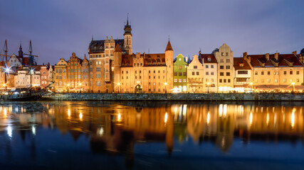 Gdansk waterfront at night glows with historic elegance — a moored galleon and golden reflections mirror the city’s seafaring soul beneath a tranquil Baltic sky.