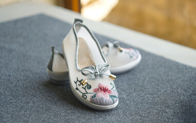 Girls' shoes in floral fabric on the carpet