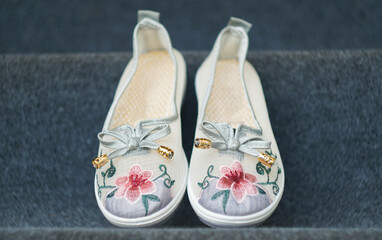 Girls' shoes in floral fabric on the carpet