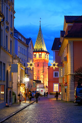 Mangturm tower in Lindau at Lake Constance, colorfully lit in festive evening mood.