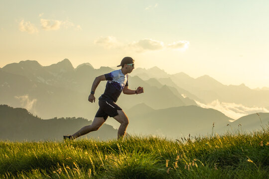 Man trail running across a scenic mountain landscape