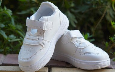 White sneakers on the ground in nature