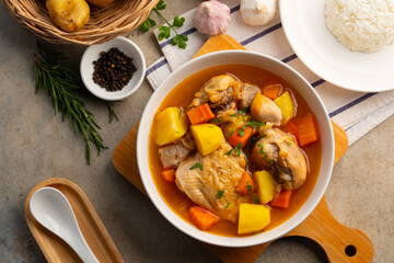 Chicken stew in white plate.Slow cooked chicken,a rich and hearty mix of tender chicken and crispy skin smothered in gravy-like sauce.Top view.