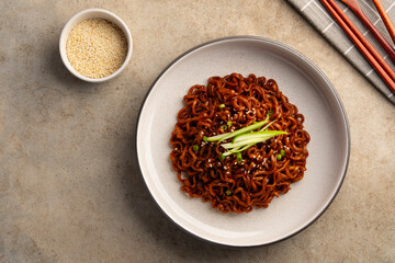 korean Jajangmyeon instant noodles.Korean black spaghetti with roasted chajang sauce in a plate.Top view.