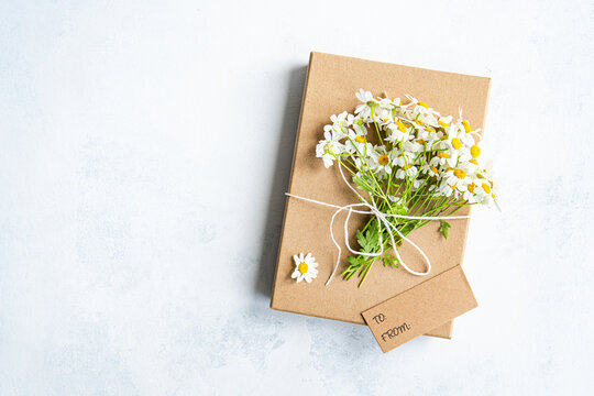 Top view of daisy bouquet on a wrapped gift