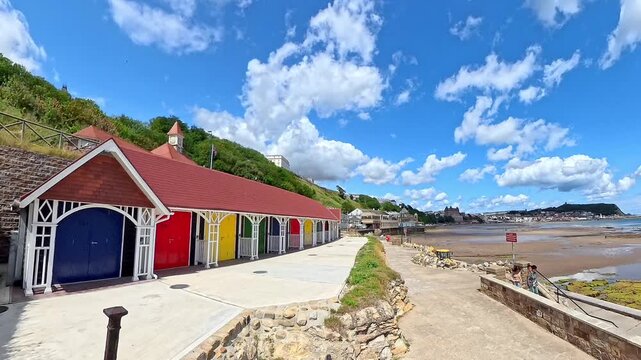 View down the promenade in Scarborough's South Bay on a bright and sunny summer day. Panning shot