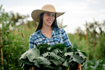 Smiling Female Farmer Holding Fresh Harvested Vegetables in Farm Field