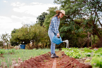 Young Woman Watering Plants in a Lush Rural Garden