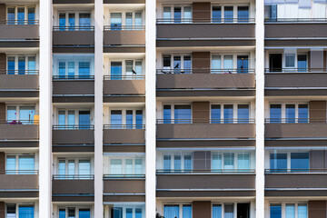Symmetrical apartment facade with brown panels and repeating balconies