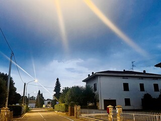 Twilight scene of a residential street with striking light rays shining through the evening sky...