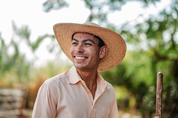 Joyful Latino Farmer Smiling in the Sun Wearing a Straw Hat