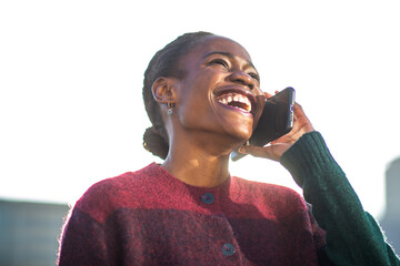 African American woman laughing joyfully while on phone call