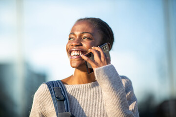 Happy African American woman on phone with joyful expression