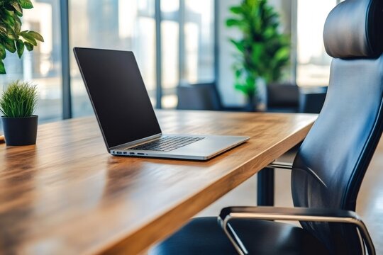 Modern office desk with laptop showing blank screen and ergonomic chair, perfect workspace for productive work