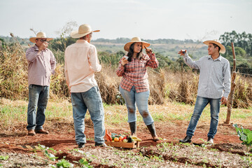 Group of Farmers Relaxing In The Field With Drinks