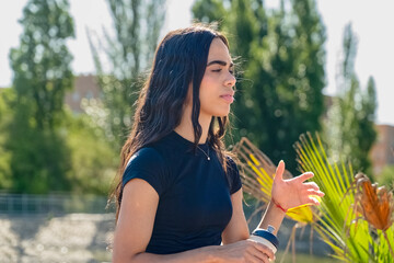 Young athlete woman drinking water after training outdoors in a park
