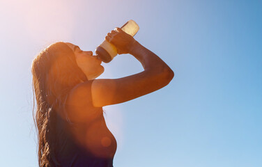 Female athlete refreshing and hydrating during a sunny summer workout