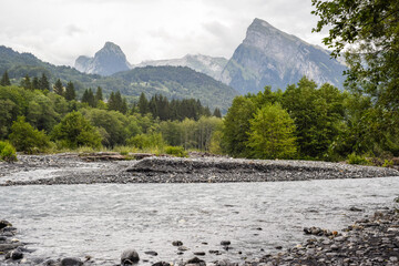 Mountain range above a forest a river in a beautiful dramatic landscape