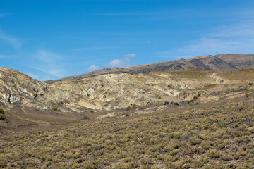 Arid Landscape with Rolling Hills and Blue Sky