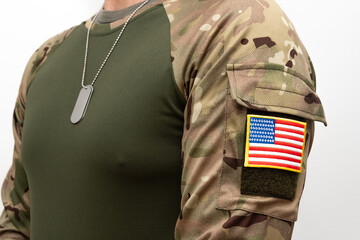 Fototapeta premium Soldier in army clothing with US flag patch and army dog tags on his chest.