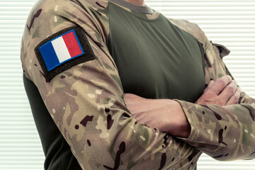 Fototapeta premium Soldier with French flag on military uniform, white background.