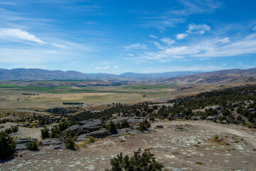 Vast Landscape with Rolling Hills and Distant Mountains