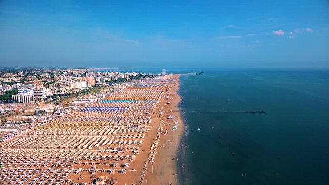 Aerial view of large equipped sandy beaches. Umbrellas and sun loungers for vacationers by the sea. Vacation on the Adriatic Sea. Ferris wheel. Traveling on Europe. Vacation in Italy Rimini 21.07.2025