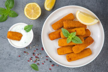 Fish and chips .Close up of crispy breaded deep fried fish fingers with breadcrumbs served with remoulade sauce and lemon