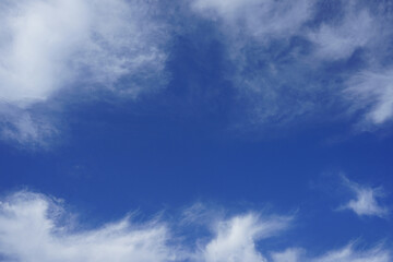 Light blue azure sky. White fluffy clouds along the edges. Background template. Frame border. Clear sunny summer day. Cleanliness purity freshness freedom peace concept. Design.