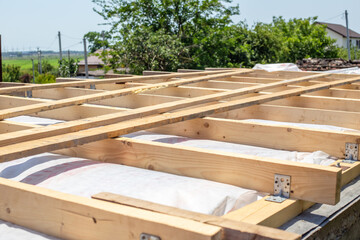 The timber frame of the roof of the building is in the process of being erected, structural support