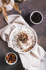 Ice cream bar with chocolate and nuts on a plate on a table top and vertical view