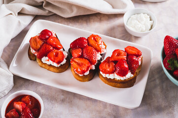 Sandwiches with cream cheese and fried strawberries on a plate on a table