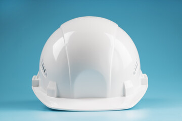 White safety helmet on a blue background with free space