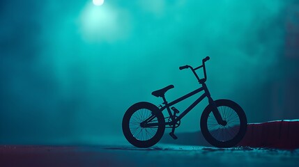 Obraz premium Bmx bike illuminated by dramatic teal lighting and smoke