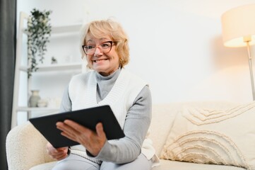 telemedicine concept, old woman with tablet pc during an online consultation with her doctor in her living room