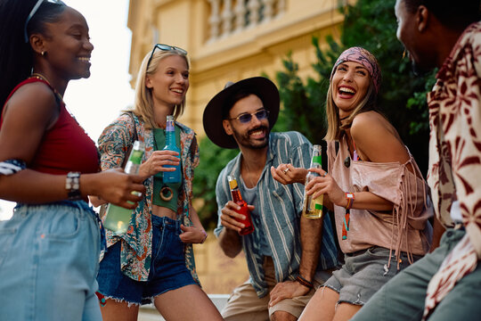 Cheerful diverse festival goers having fun while attending open air music concert in summer.