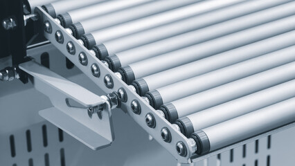 Conveyor belt with a white handle on the end. belt is made of metal and is silver in color