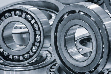 Collection of different sized and colored ball bearings. Some are gold and some are silver. The gold ones are in the middle of the collection