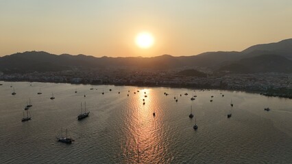 Sunset coastal city. Boats coastal town. Coastal mountain landscape, sea resort yachts, golden hour