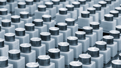 Row of metal cylinders are lined up in a row. The cylinders are all the same size and shape