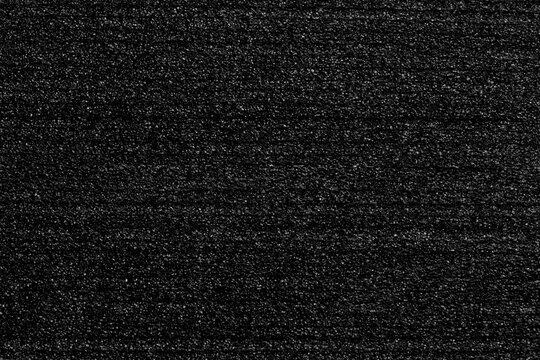 Black porous foam padding with layered structure and soft textured surface. Protective packaging material. Abstract dark background
