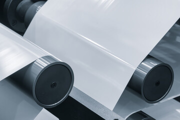 A machine with a roll of polyethylene plastic wrapping film on it. The machine is in a factory....