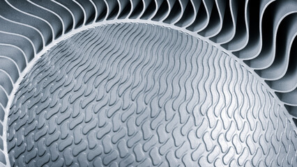 metal piece with a pattern created by a 3D printer. lines are arranged in a spiral pattern, creating a sense of movement and energy. Adaptive technologies concept background.