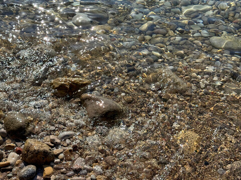 Pebbles and stones in sea clear water 