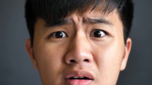 Close-up portrait of a young man with a worried, apprehensive expression.