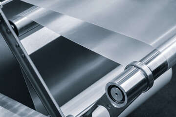 roll of plastic polyethylene film is cut by a food packaging machine. Industrial concept background. © Aleksandr Matveev