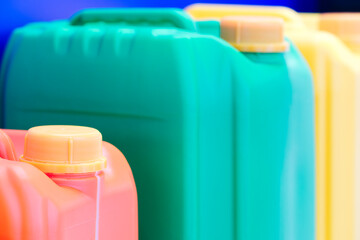 Row of plastic containers in various colors.  containers are lined up next to each other. colors of...